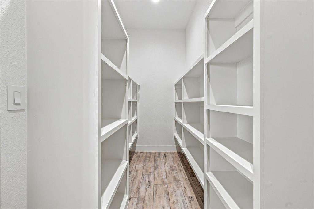 8140 Lavender Road Springtown, TX 76082 - Photo 14 of 40 Built-in shelving units, recessed ceiling lighting, textured wall finish, and wood-finish flooring
