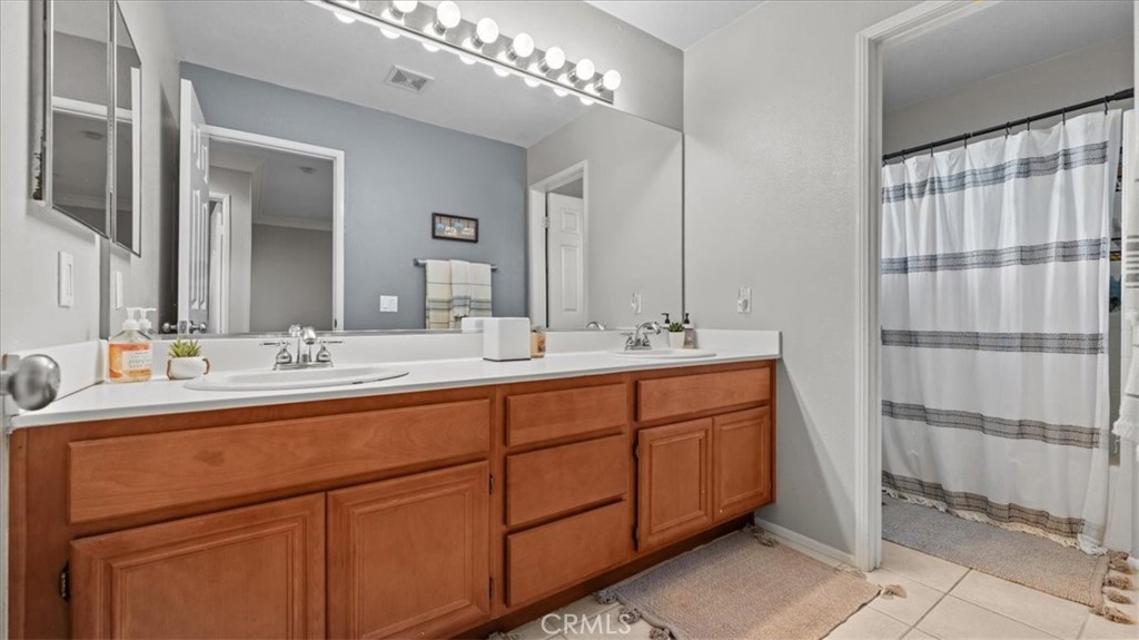 19829 Adirondack Lane Riverside, CA 92508 - Photo 16 of 34 a bathroom with double vanity sink and a mirror