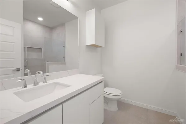a bathroom with a sink a toilet and a mirror