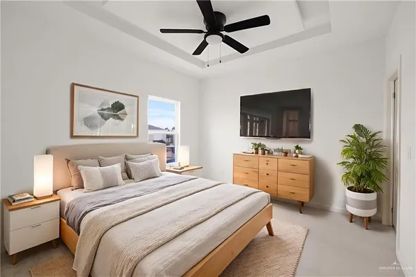 a bedroom with a bed a couch and a flat screen tv