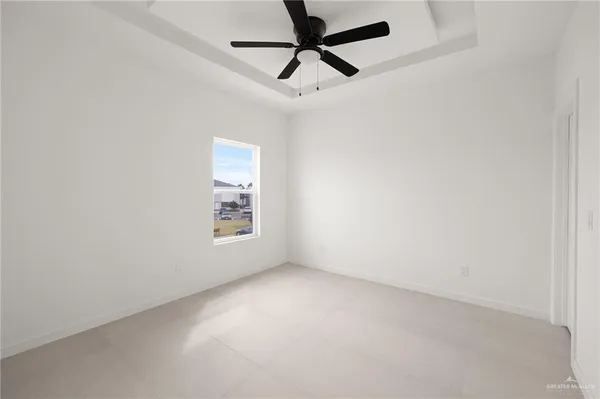 an empty room with a window and a fan