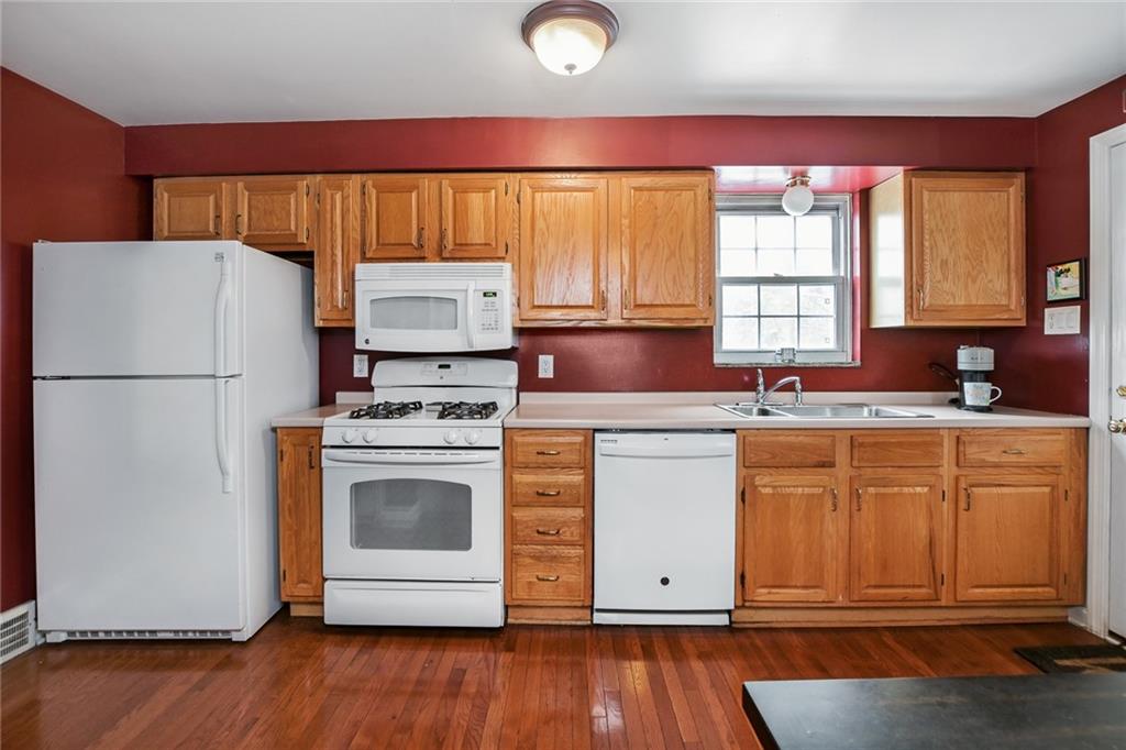 2019 Brookfield Road Pittsburgh, PA 15243 - Photo 3 of 18 a kitchen with granite countertop a refrigerator a sink dishwasher a stove and white cabinets with wooden floor