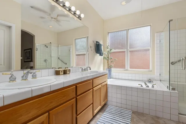 a bathroom with a tub sink and mirror