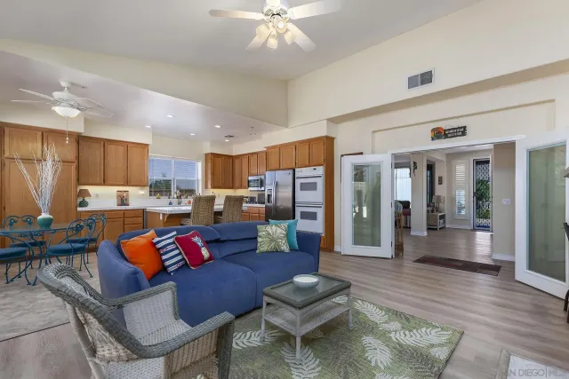 a living room with furniture kitchen view and a chandelier