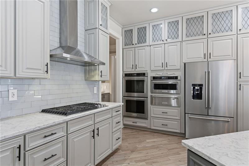 1565 Bramble Bush Way Suwanee, GA 30024 - Photo 16 of 62 a kitchen with stainless steel appliances a refrigerator stove and white cabinets