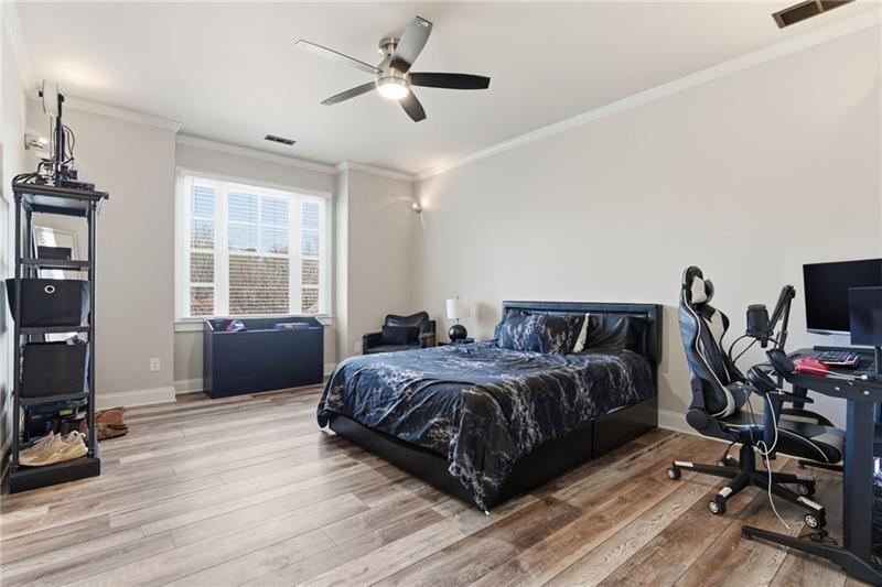 1565 Bramble Bush Way Suwanee, GA 30024 - Photo 26 of 62 a bedroom with a bed a large window and wooden floor