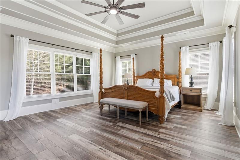 1565 Bramble Bush Way Suwanee, GA 30024 - Photo 30 of 62 a spacious bedroom with a bed and a large window with wooden floor