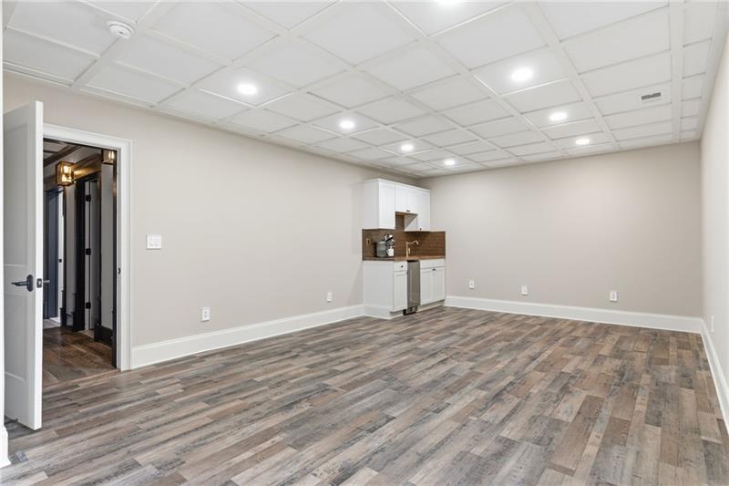 1565 Bramble Bush Way Suwanee, GA 30024 - Photo 55 of 62 an empty room with wooden floor and a wooden bench