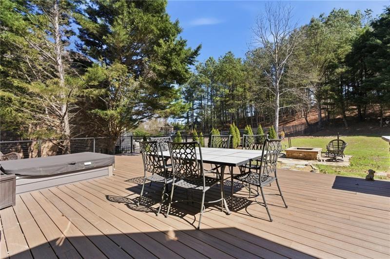 1565 Bramble Bush Way Suwanee, GA 30024 - Photo 56 of 62 a view of a roof deck with table and chairs a barbeque with wooden floor and fence