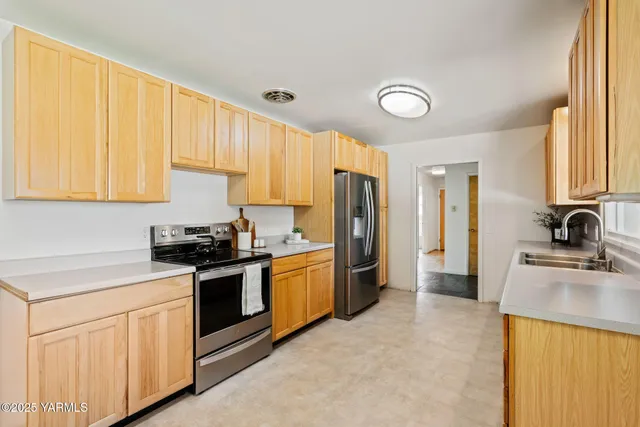 a kitchen with stainless steel appliances granite countertop a stove a sink dishwasher and a refrigerator