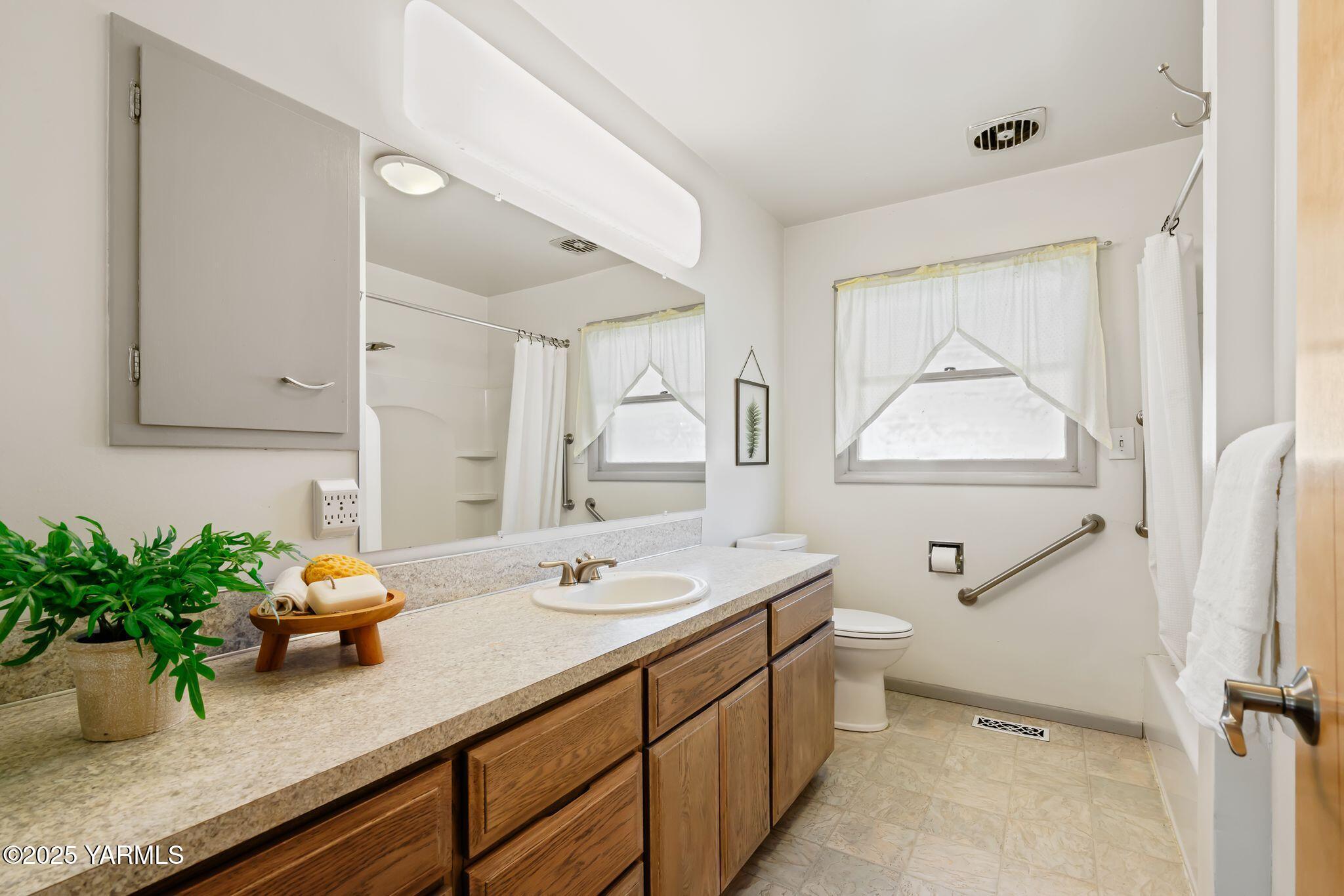 1020 Elm Street Prosser, WA 99350 - Photo 16 of 28 a bathroom with a granite countertop sink a large mirror and shower