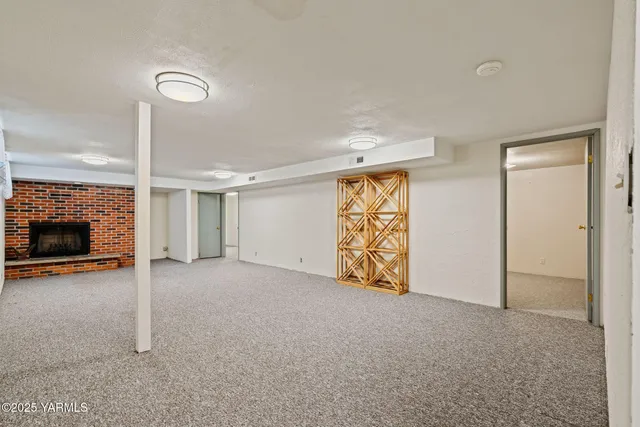 an empty room with windows and fireplace