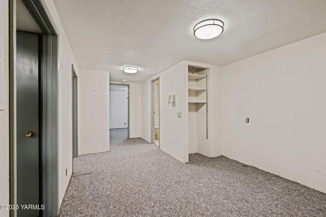 an empty room with a window and fire place