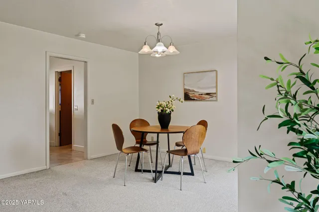 a view of a dining room with furniture and chandelier