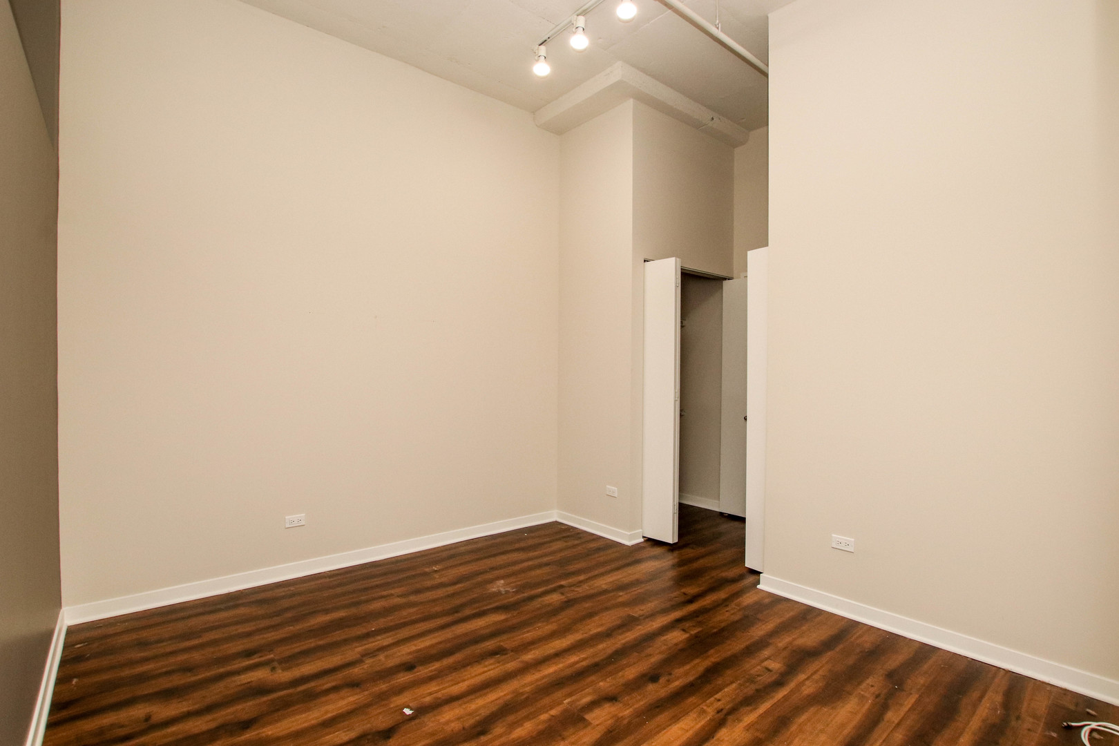 1313 West Randolph Street, Unit 203 Chicago, IL 60607 - Photo 6 of 18 a view of a room with wooden floor and white walls