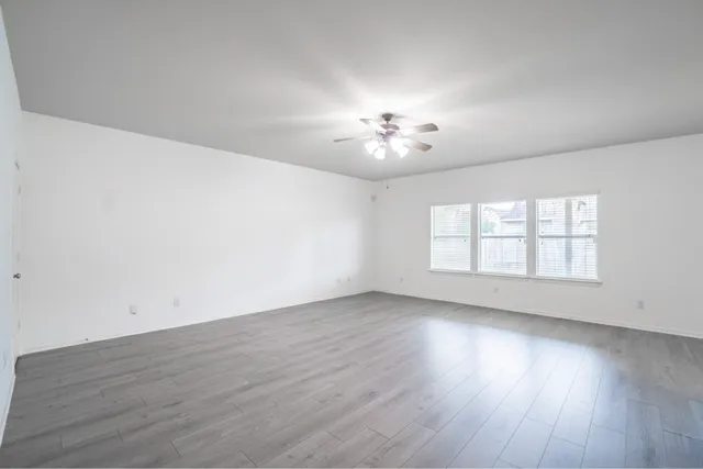 an empty room with wooden floor and window