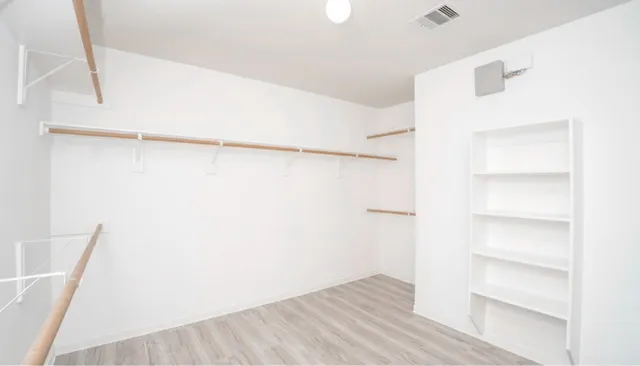 a view of walk in closet with empty racks