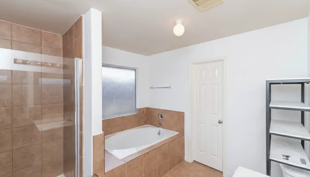 a bathroom with a tub shower and a sink