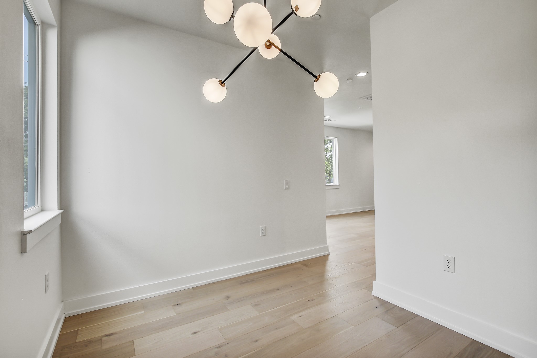 4127 East 12th Street, Unit 3 Austin, TX 78721 - Photo 14 of 29 Unfurnished room featuring a chandelier, baseboards, light wood-style flooring, and recessed lighting