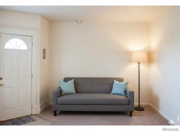 a living room with furniture and a lamp