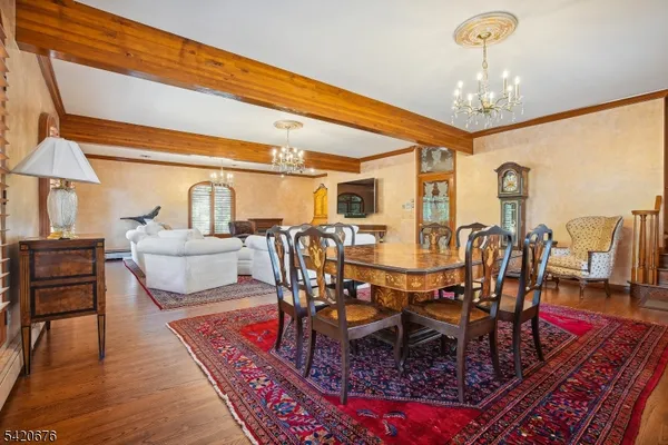 a view of a dining room with furniture a chandelier and wooden floor