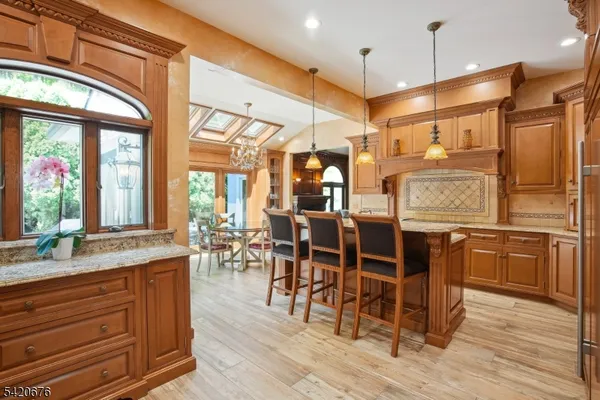a dining hall with stainless steel appliances granite countertop a stove and wooden cabinets