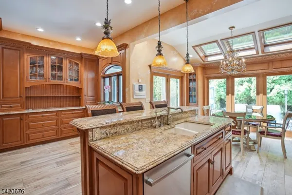 a dining hall with stainless steel appliances granite countertop a kitchen island a stove and a sink