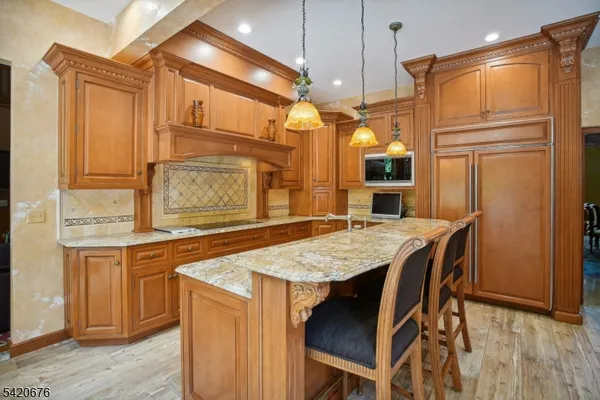 a open kitchen with a refrigerator a oven and a stove with wooden floor