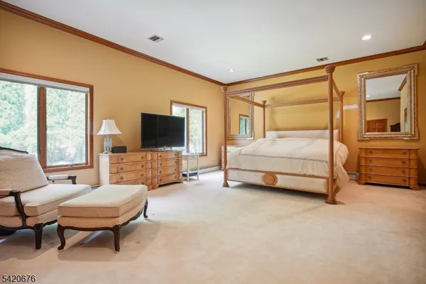 a spacious bedroom with a bed and a flat screen tv