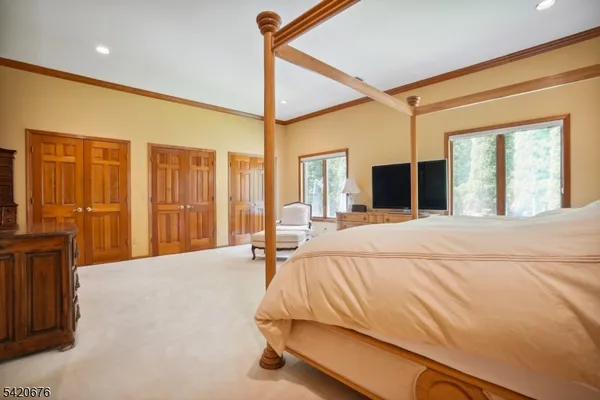 a bed sitting in a spacious bedroom next to a window