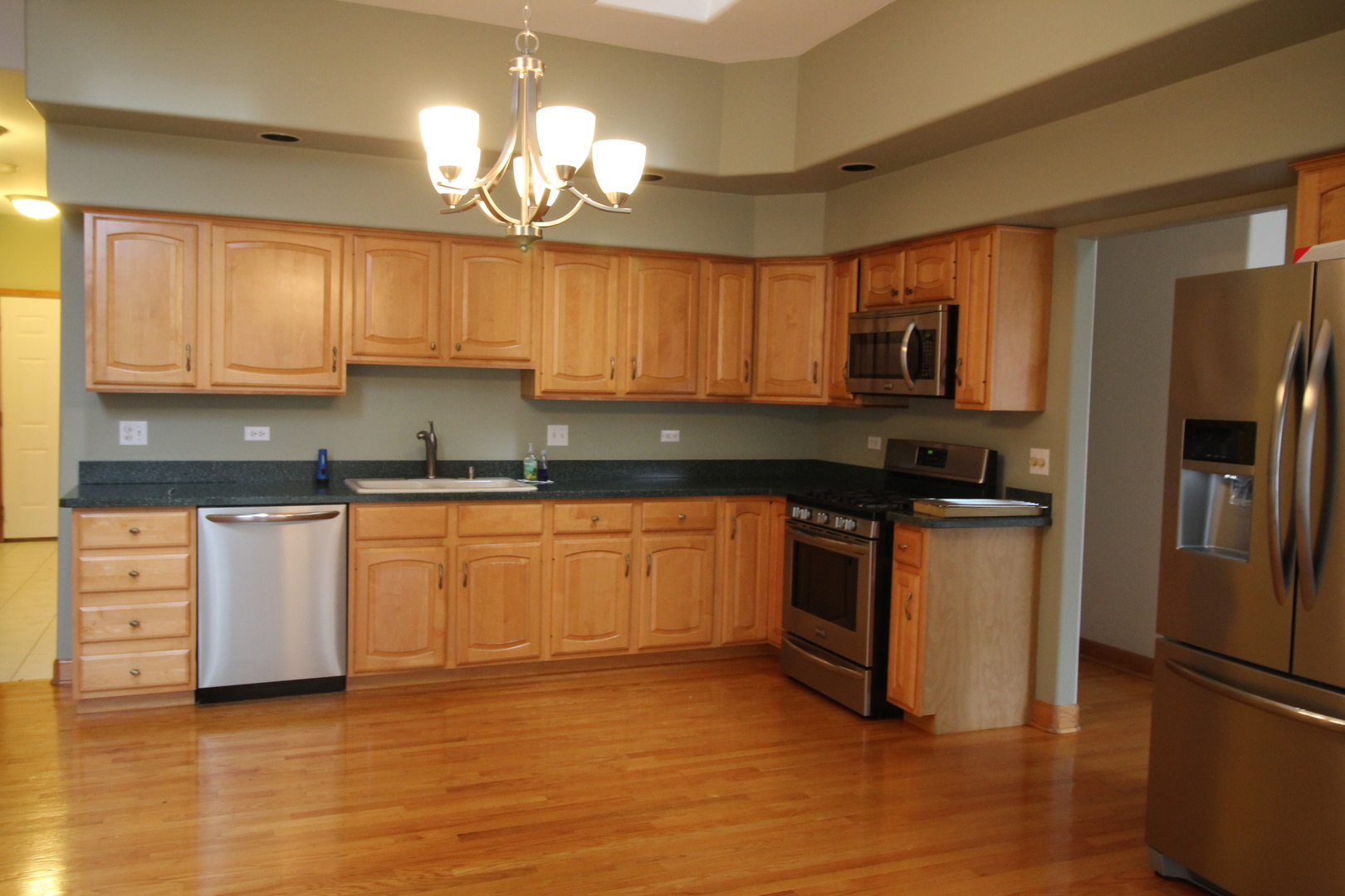 10 Moorings Drive Palos Heights, IL 60463 - Photo 16 of 19 a kitchen with granite countertop a refrigerator a stove a sink and white cabinets with wooden floor