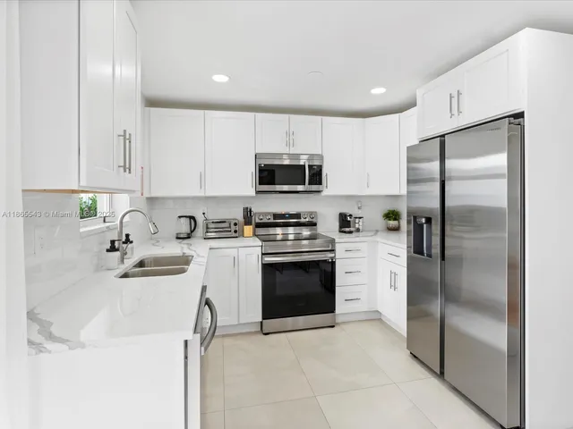 a kitchen with white cabinets and stainless steel appliances