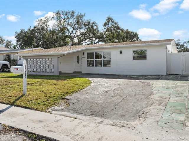 a view of a house with pool and sitting area
