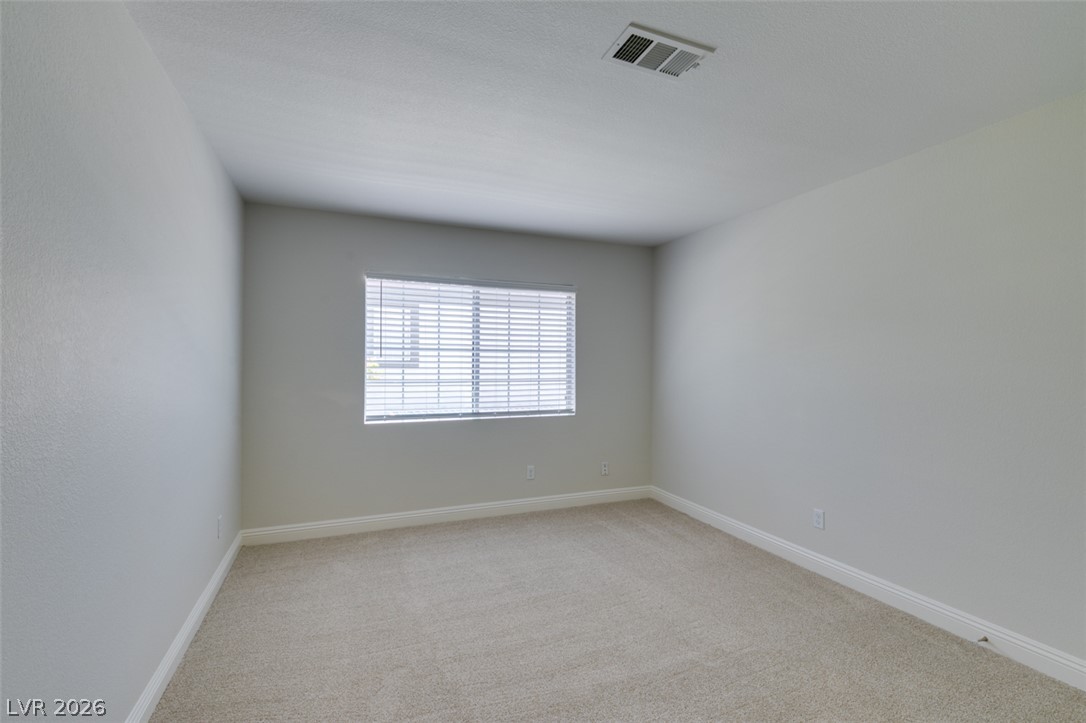 200 Luninborg Street Henderson, NV 89074 - Photo 7 of 40 A well-lit room offers pristine carpeting and a window with blinds, creating a versatile space.