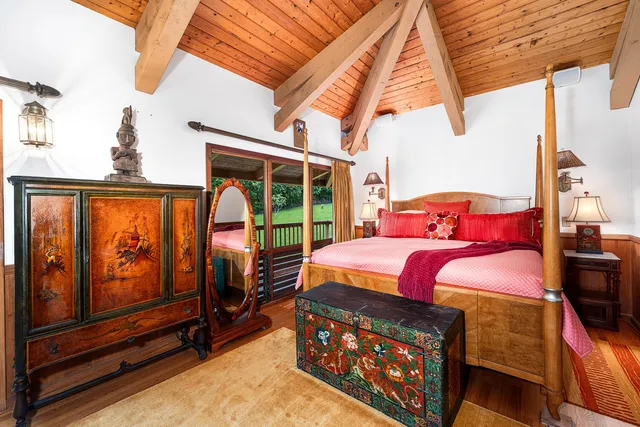 a bedroom with a bed next to a window