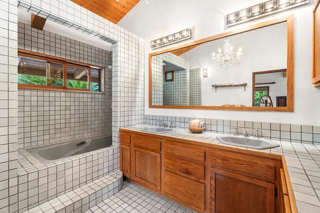 a bathroom with a sink a bathtub and mirror