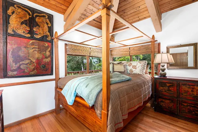 a bed sitting in a bedroom next to a window