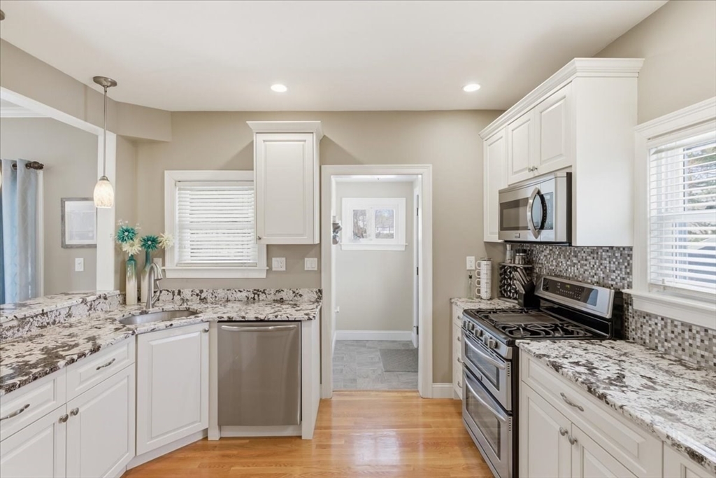 72 Crane Street Dedham, MA 02026 - Photo 15 of 42 a kitchen with stainless steel appliances granite countertop a stove top oven a sink dishwasher a refrigerator and a oven with wooden floor
