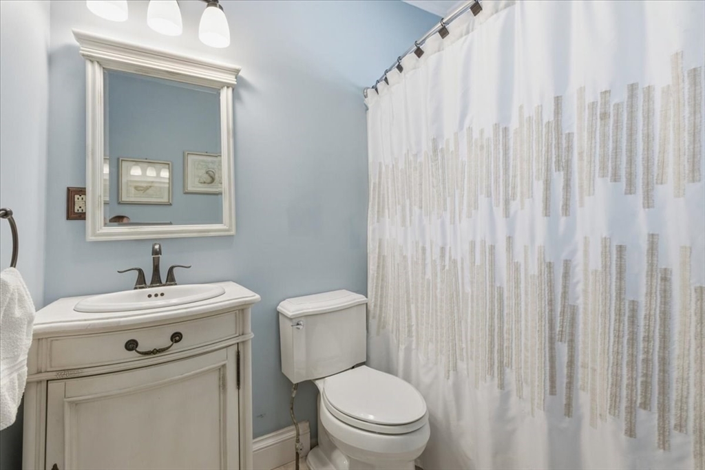 72 Crane Street Dedham, MA 02026 - Photo 21 of 42 a bathroom with a toilet sink vanity and mirror