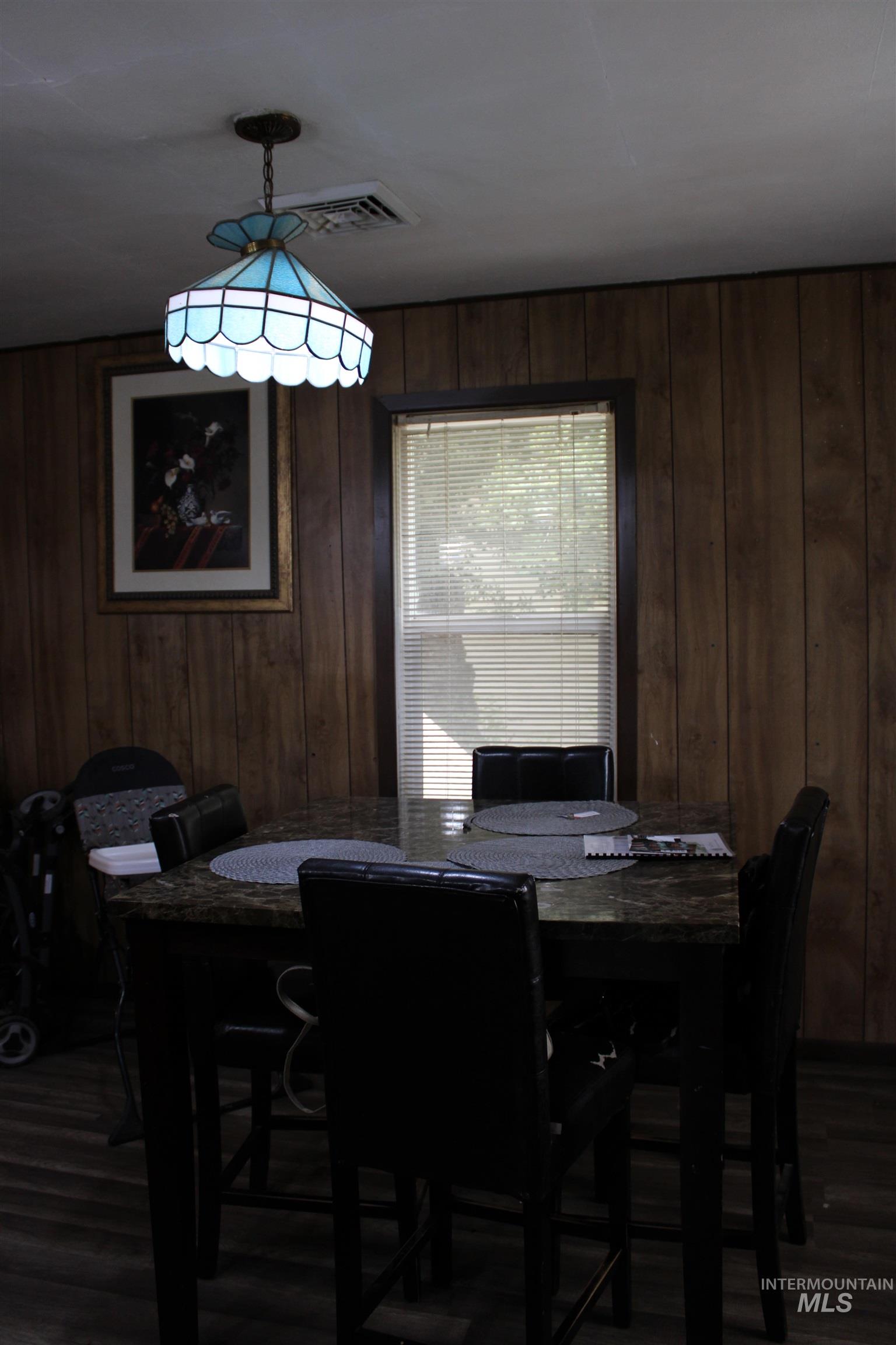 106 3rd Street West Declo, ID 83323 - Photo 8 of 23 Dining room featuring dark wood-style floors and wood walls