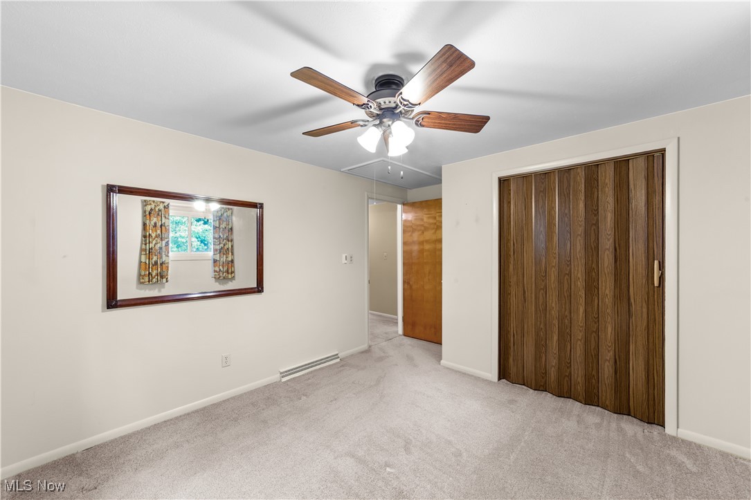 648 Rehwinkle Road Northfield, OH 44067 - Photo 18 of 38 Unfurnished bedroom featuring attic access, carpet flooring, a ceiling fan, and a closet