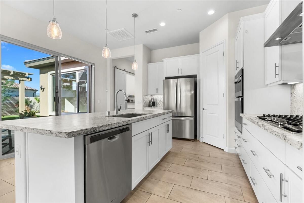 19 Syrah Rancho Mirage, CA 92270 - Photo 16 of 71 a kitchen with stainless steel appliances granite countertop a stove and a refrigerator