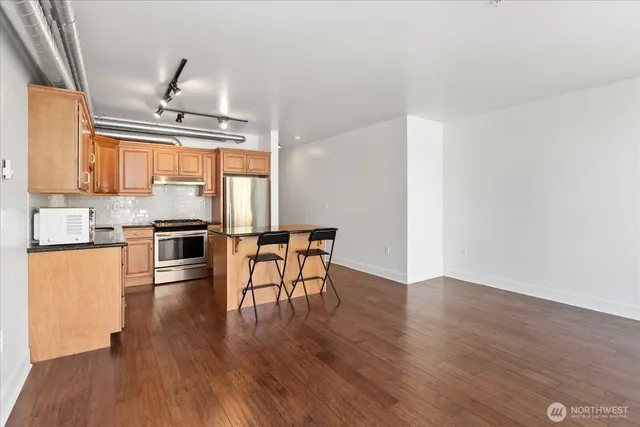 a kitchen with granite countertop wooden floors and stainless steel appliances