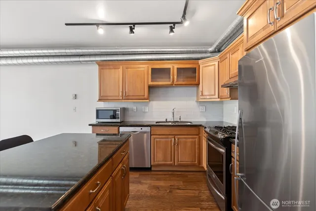 a kitchen with stainless steel appliances granite countertop a sink stove and refrigerator