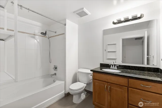 a bathroom with a bathtub shower sink vanity and toilet