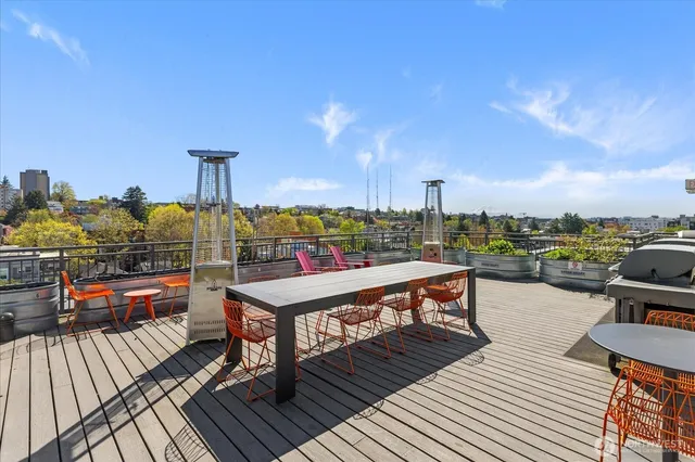 a view of a rooftop deck with couch and chairs