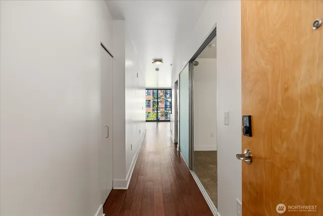 a view of a hallway with wooden floor and staircase