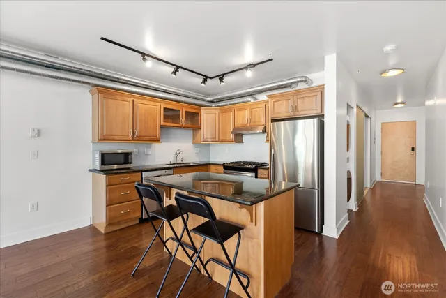 a kitchen with stainless steel appliances granite countertop a refrigerator and a stove top oven