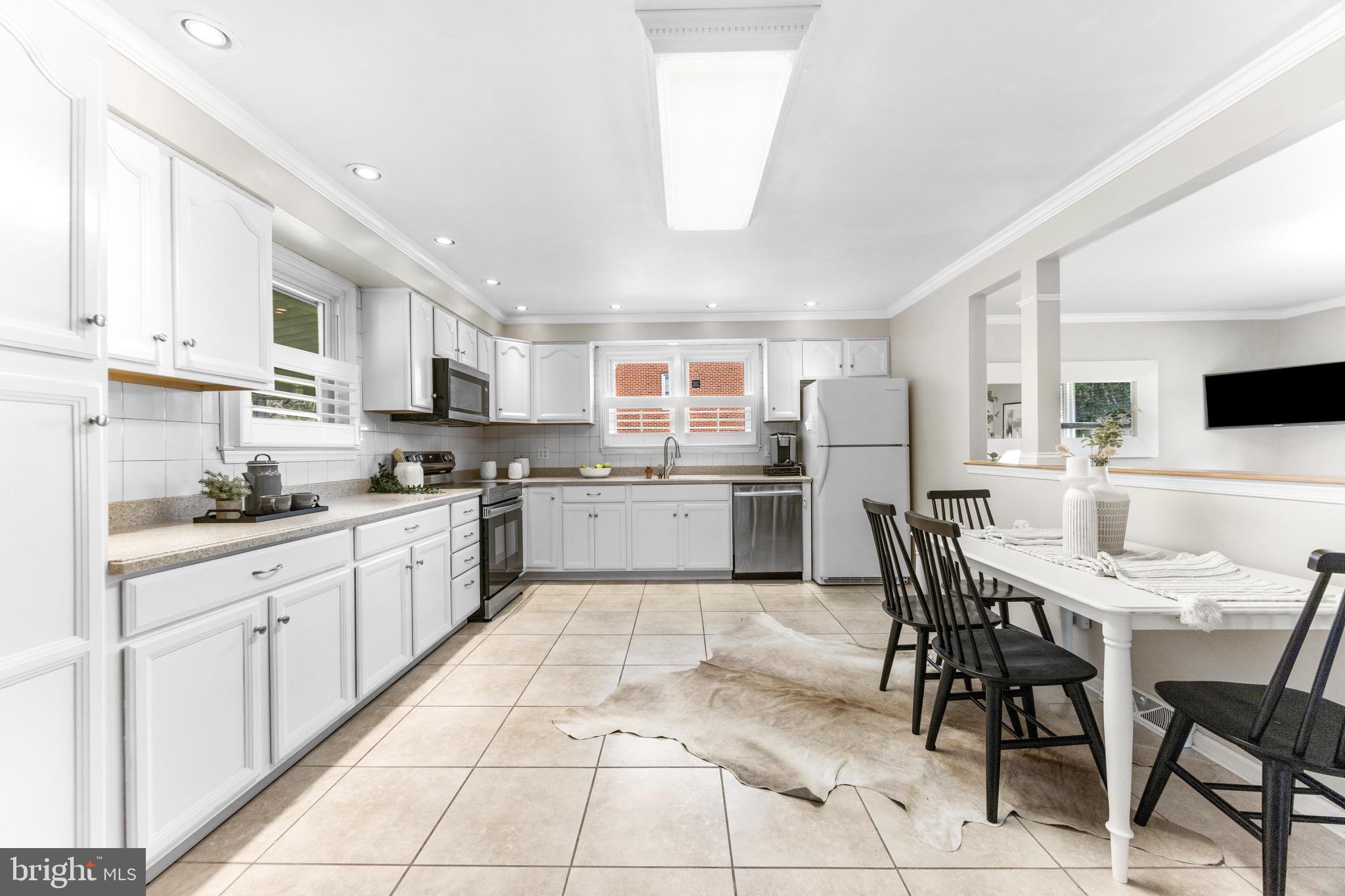 586 Forest View Road Linthicum Heights, MD 21090 - Photo 6 of 28 a kitchen with stainless steel appliances granite countertop a table and chairs in it