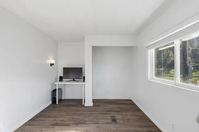 a view of a kitchen with a sink a fireplace wooden floor and window